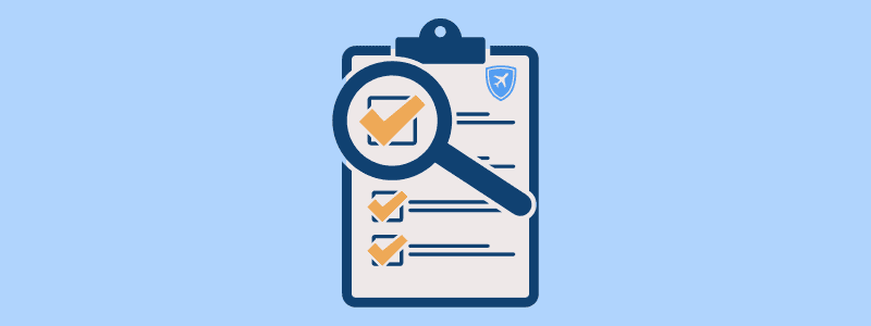 Clipboard checklist with a magnifying glass and a small travel shield icon, symbolizing what to look for in Canadian travel health insurance.